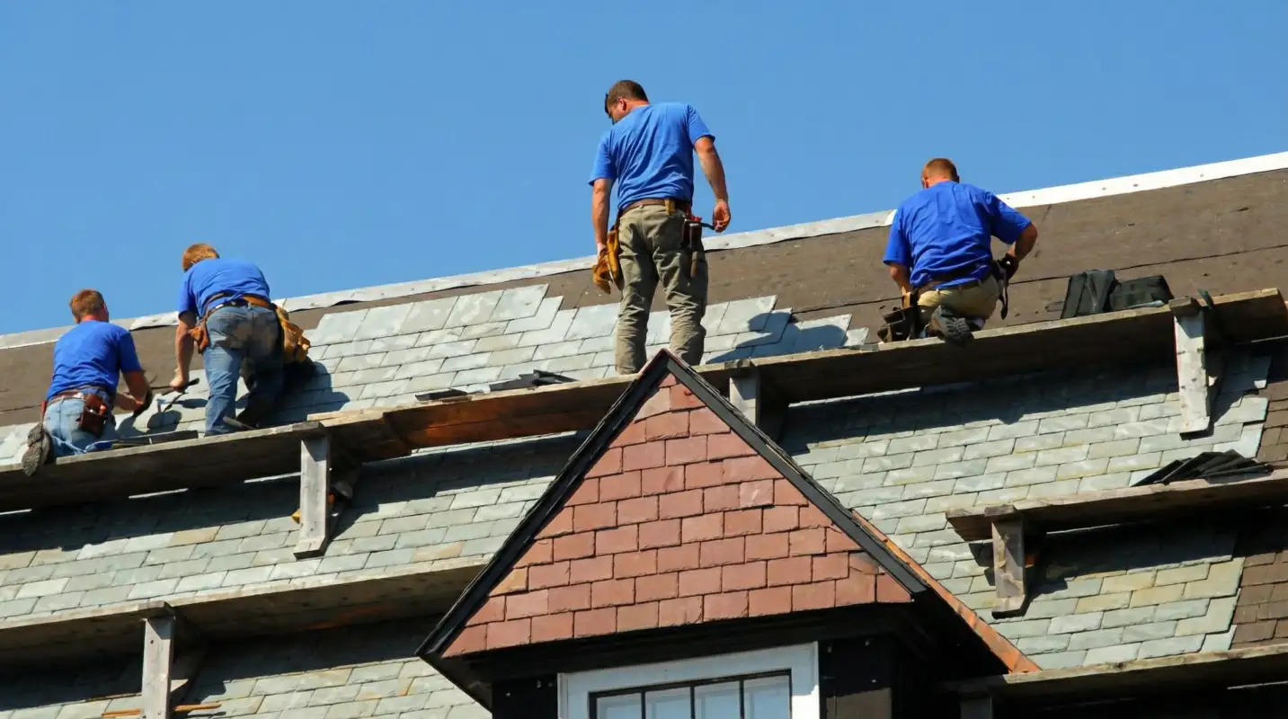 Roof replacement in progress with a team of professional contractors installing new shingles on a residential home in Detroit, Mi